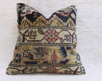 May include: A decorative pillow with a beige background and intricate floral and geometric patterns in shades of blue, brown, and pink.