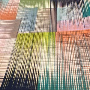 May include: Abstract textile pattern featuring a patchwork of colorful rectangles. The design incorporates shades of orange, green, blue, and gray, with vertical and horizontal lines creating a textured effect. The overall aesthetic is modern and geometric.
