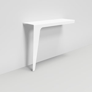 Peut inclure: Une console murale blanche avec une seule jambe angulaire. La table est faite d'un matériau lisse et moderne.