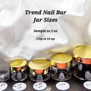 May include: Five clear plastic jars with gold lids, ranging in size from a sample jar to a 2 ounce jar. The jars are labeled with their size in ounces. The text "Trend Nail Bar Jar Sizes" is at the top of the image. The text "Sample to 2 oz" and "1 tsp to 14 tsp" are below the title.