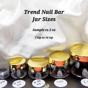 May include: Five clear glass jars with gold lids, ranging in size from a sample size to 2 ounces. The jars are labeled with their size in ounces. The text "Trend Nail Bar Jar Sizes" is at the top of the image. The text "Sample to 2 oz" and "1 tsp to 14 tsp" are below the title.
