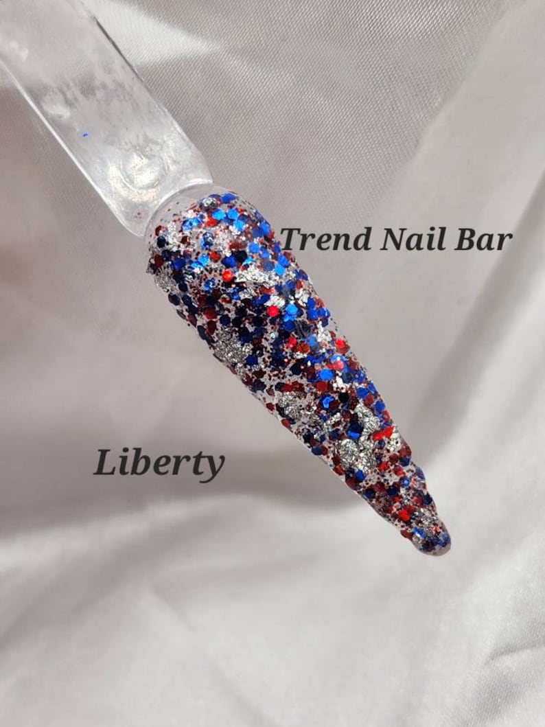 May include: A close-up of a red, white, and blue glitter nail polish with the text "Trend Nail Bar" and "Liberty" on a white background.