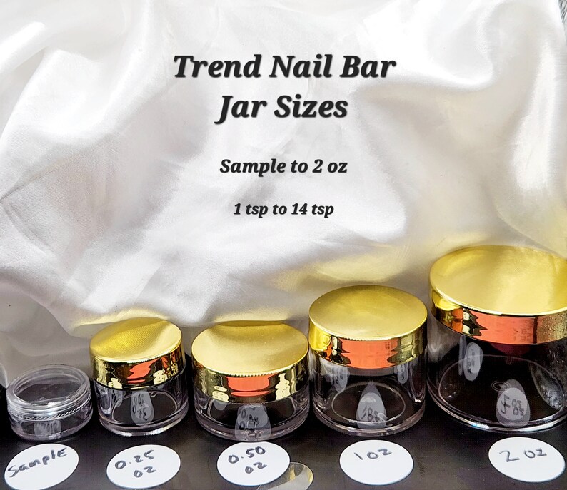 Pu&ograve; includere: Cinque barattoli di plastica trasparente con coperchi dorati, che vanno da un barattolo di campione a un barattolo da 2 once. I barattoli sono etichettati con la loro dimensione in once. Il testo "Trend Nail Bar Jar Sizes" &egrave; nella parte superiore dell'immagine. Il testo "Sample to 2 oz" e "1 tsp to 14 tsp" sono sotto il titolo.