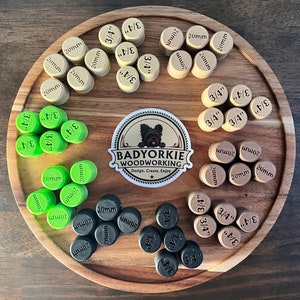 May include: Assortment of wooden plugs in various sizes, including 3/4 inch and 20 mm, arranged in a circle on a wooden surface. The plugs are in three colors: brown, green, and black. A sticker with the text "BADYORKIE WOODWORKING Design. Create. Enjoy" is in the center of the circle.