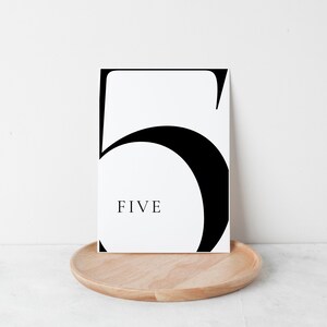 Puede incluir: Tarjeta de n&uacute;mero de mesa imprimible en blanco y negro con el n&uacute;mero "5" y la palabra "CINCO" en una fuente moderna.