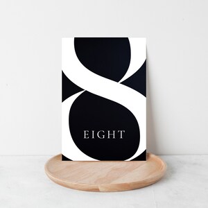 May include: Black and white printable art print with a large white number eight and the word "EIGHT" in white text on a black background.