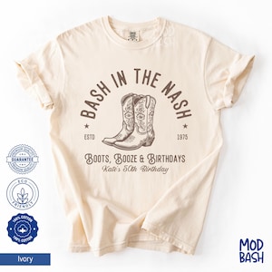 Puede incluir: Una camiseta beige con un diseño gráfico marrón que dice "Bash in the Nash" con un par de botas de vaquero. El texto también dice "Boots, Booze & Birthdays" y "Kate's 50th Birthday".