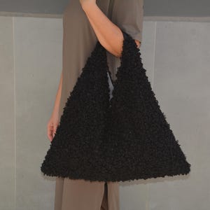 May include: A large black fuzzy tote bag with a slouchy, unstructured design.