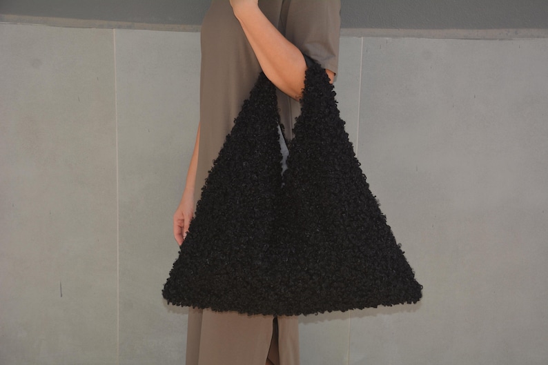 May include: A large black fuzzy tote bag with a slouchy, unstructured design.