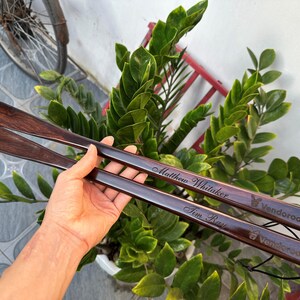 Pode incluir: Duas cal&ccedil;adeiras longas de madeira castanho-escura com acabamento polido. Cada cal&ccedil;adeira est&aacute; gravada com um nome, Matthew Whitaker e Tim Ray, e apresenta o texto Vendoroo com um pequeno &iacute;cone de coelho perto da extremidade do cabo.
