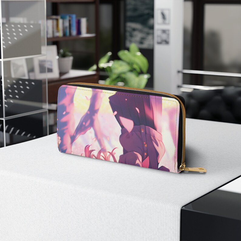 Puede incluir: Una cartera con cremallera rosa y morada con una ilustraci&oacute;n de estilo anime de dos personas de pie frente a un fondo rosa y amarillo.