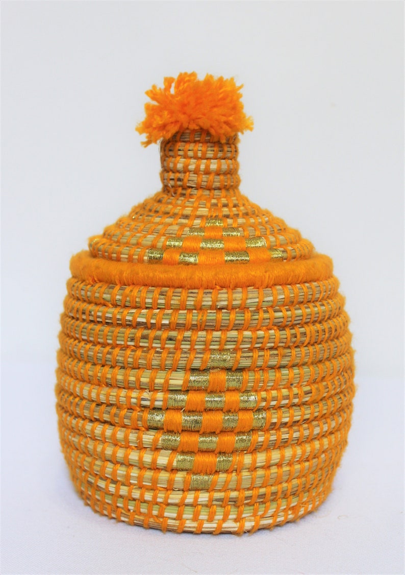Peut inclure: Panier tiss&eacute; orange avec une bordure dor&eacute;e et un pompon orange moelleux sur le couvercle.