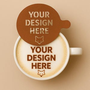 May include: A white ceramic coffee cup filled with a latte, topped with a design and a brown paper lid. The design on the latte and lid reads "YOUR DESIGN HERE" with a fox icon. The background is a solid beige colour.