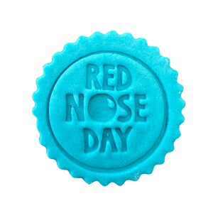 May include: A blue round cookie with the words "Red Nose Day" embossed on it.