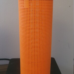 May include: Orange plastic mesh basket with a handle. The basket is sitting on a digital scale.