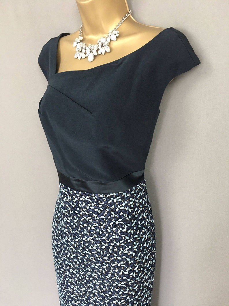 The Ronald Joyce designer Veni Infantino Dress in navy is a stunning two-piece outfit that will make you look effortlessly elegant.