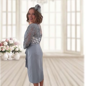 Rosa Clara Mother of the Bride cocktail dress in crepe sateen with lace on the bodice. Round neckline with three-quarter sleeves and beaded brooch at the waist.
Suitable for Mother of the Bride, Mother of the Groom,