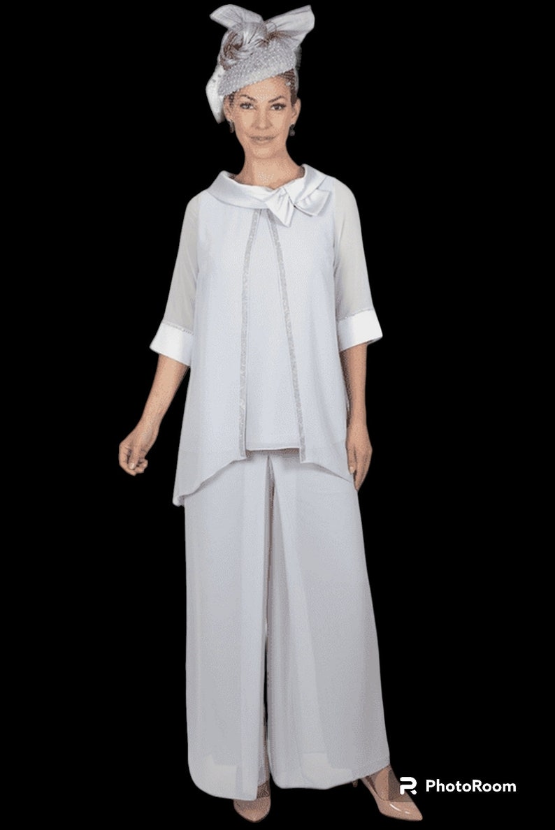 The top/jacket is made of chiffon material and features a pull-over style. It is lined and adorned with embellished beads, while also having long cut sleeves. The trousers are lined with a chiffon overlay, offering a wide leg design.