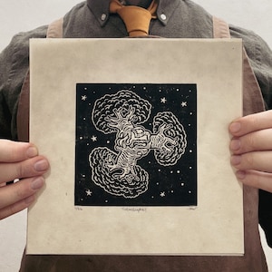 Puede incluir: Grabado en linóleo en blanco y negro de un árbol con un fondo de noche estrellada. La impresión se titula "¡catástrofe!" y está numerada 1/26.