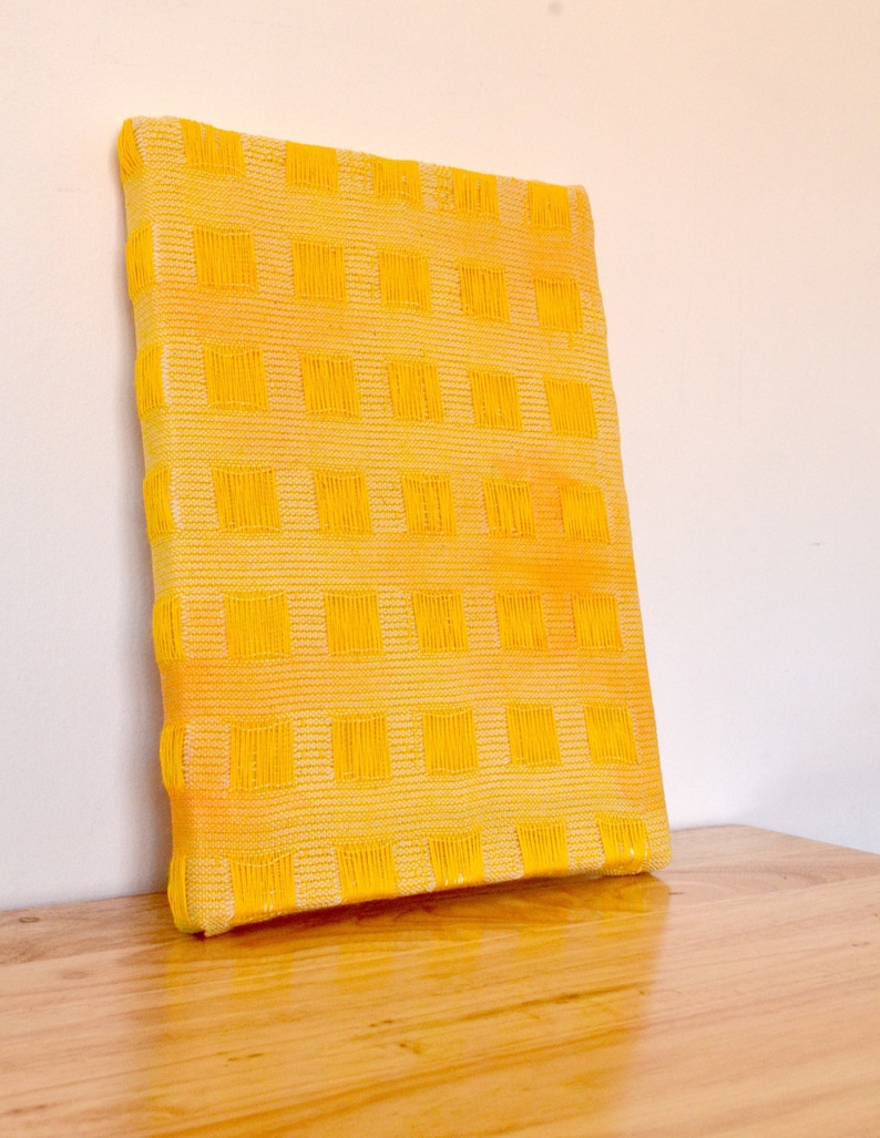May include: A yellow canvas painting with a grid pattern of squares.