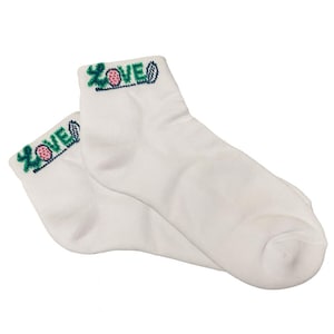 May include: A pair of white ankle socks. The top of each sock features the word "LOVE" embroidered in green, pink, and blue. The socks are made of a soft, comfortable material.