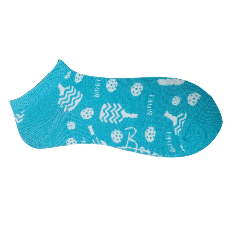 May include: A single turquoise ankle sock with a white pickleball paddle and ball pattern. The word "dink!" is repeated throughout the design. The letter "B" is also visible in the design.