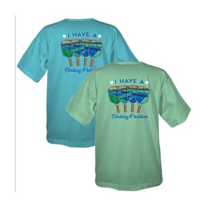 K&ouml;nnte beinhalten: Zwei hellblaue und gr&uuml;ne T-Shirts mit einer Grafik von vier Pickleball-Schl&auml;gern und dem Text "Ich habe ein Dink-ing Problem".