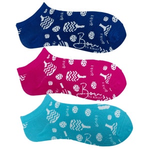 May include: Three pairs of no-show socks in blue, fuchsia, and turquoise. Each sock features a white pattern of pickleball paddles, balls, and the text "dink!" and "Born to Rally".