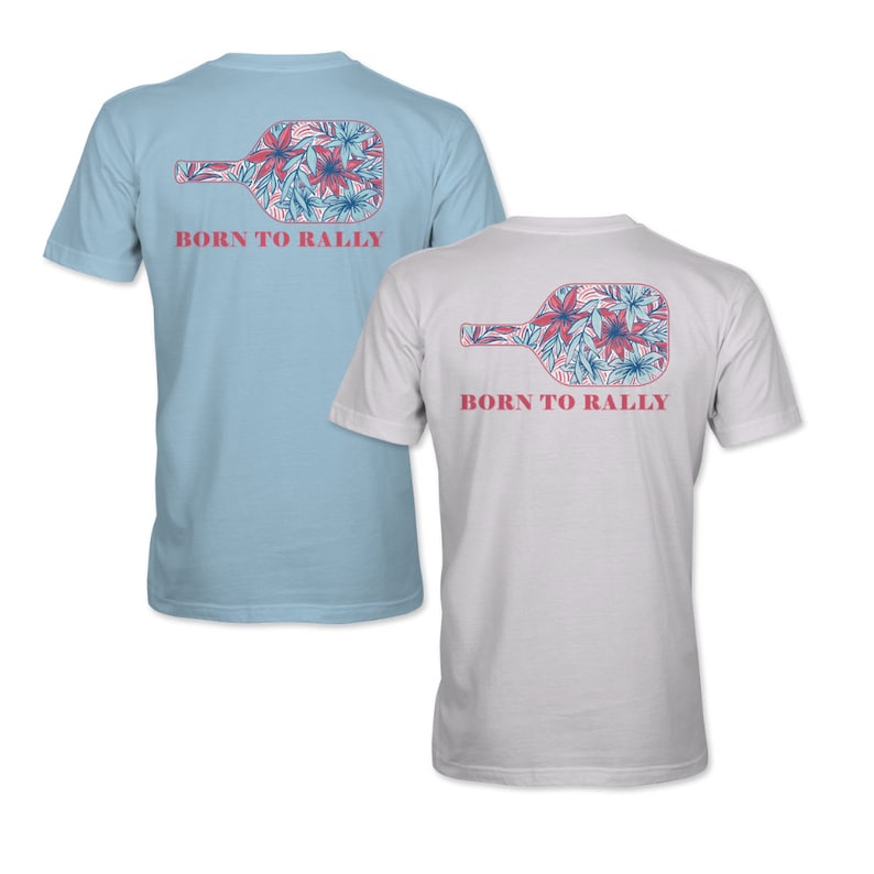 K&ouml;nnte beinhalten: Zwei T-Shirts mit einem floralen Paddel-Design auf der R&uuml;ckseite. Der Text "BORN TO RALLY" ist unter dem Paddel-Design gedruckt. Ein Shirt ist hellblau und das andere ist wei&szlig;.