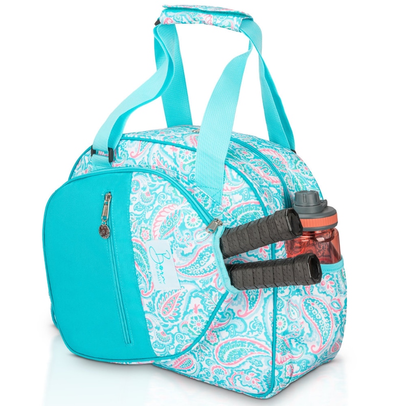 May include: A turquoise and white paisley patterned sports bag with a zipped pocket and a side pocket for a water bottle and racquet.