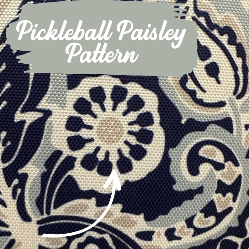 May include: A close-up of a navy blue fabric with a white paisley pattern. The pattern features a central circle with a tan centre and a ring of dark blue petals.