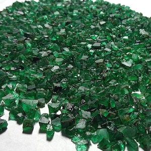 Op de afbeelding: Een grote stapel ruwe, groene smaragd edelstenen. De smaragden zijn van verschillende groottes en vormen, en ze zijn allemaal erg glanzend.