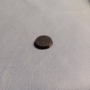 May include: A black round plastic base for miniature figures.