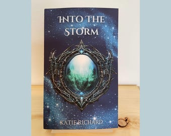 May include: A book cover with a dark blue background and a silver and green design. The title "Into the Storm" is written in white text. The author's name, "Katie Richard", is written in white text at the bottom of the cover.