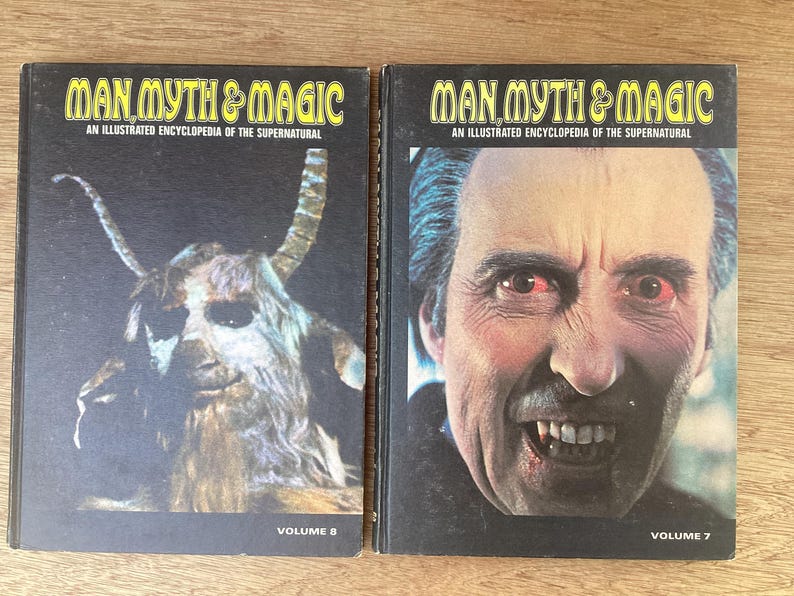 Puede incluir: Dos libros antiguos titulados "Man, Myth & Magic: An Illustrated Encyclopedia of the Supernatural". El volumen 8 presenta una criatura parecida a una cabra, mientras que el volumen 7 muestra un retrato de un hombre con dientes afilados. Ambos libros tienen cubiertas negras.