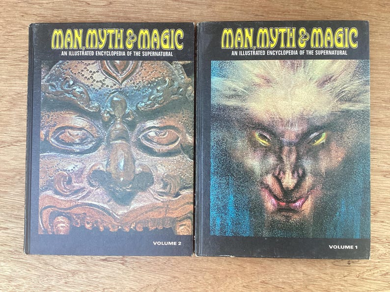 Puede incluir: Dos libros antiguos titulados "Man, Myth & Magic: An Illustrated Encyclopedia of the Supernatural". El volumen 2 presenta una talla detallada de una cara, mientras que el volumen 1 muestra una criatura con ojos amarillos brillantes. Ambos libros tienen cubiertas negras.