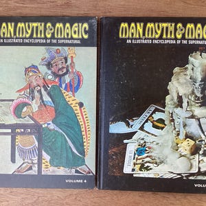 Puede incluir: Dos libros antiguos de tapa dura titulados "Man, Myth & Magic: An Illustrated Encyclopedia of the Supernatural". El volumen 4 presenta una colorida ilustraci&oacute;n de figuras asi&aacute;ticas. El volumen 3 muestra una naturaleza muerta con cartas y dados.