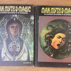 Puede incluir: Dos libros antiguos de tapa dura titulados "Man, Myth & Magic: An Illustrated Encyclopedia of the Supernatural". El volumen 10 presenta un icono religioso, mientras que el volumen 9 representa a Medusa. Ambos libros tienen cubiertas negras con letras doradas.