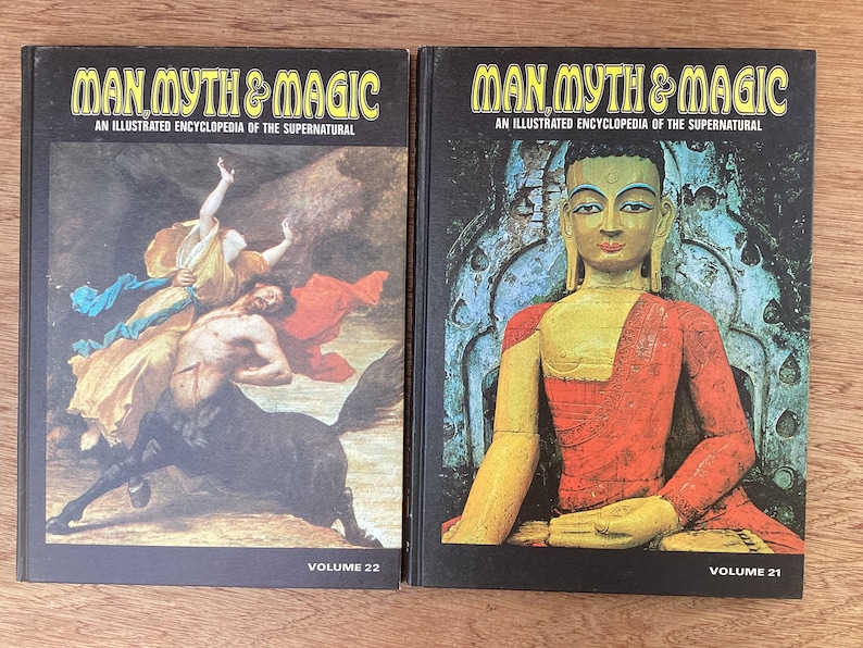 Puede incluir: Dos libros de tapa dura titulados "Man Myth & Magic: An Illustrated Encyclopedia of the Supernatural". El volumen 22 presenta una pintura de un centauro y figuras. El volumen 21 muestra una estatua de Buda sentado. Ambos libros tienen cubiertas negras.