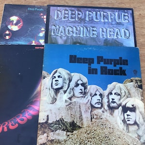May include: A collection of Deep Purple vinyl records. The album covers feature text and graphics, including "Deep Purple Machine Head", "Deep Purple in Rock", and "Fireball". The album covers are in various colors, including black, purple, and blue.