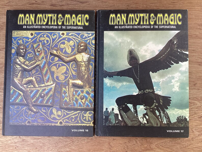 Puede incluir: Se muestran dos vol&uacute;menes de "Man, Myth & Magic: An Illustrated Encyclopedia of the Supernatural". El volumen 18 presenta una ilustraci&oacute;n dorada y azul. El volumen 17 muestra a una persona con alas de &aacute;guila. Ambos libros tienen lomos negros.