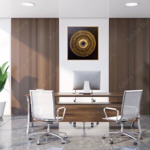 May include: A modern office interior with a wooden desk and two white mesh office chairs. A large framed abstract painting with gold and black concentric circles hangs on the wall behind the desk.