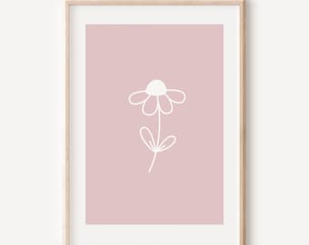 May include: A framed wall art print featuring a simple white line drawing of a single flower centered on a solid dusty pink background. The artwork is enclosed within a light-toned wooden frame with a white mat border surrounding the central image.