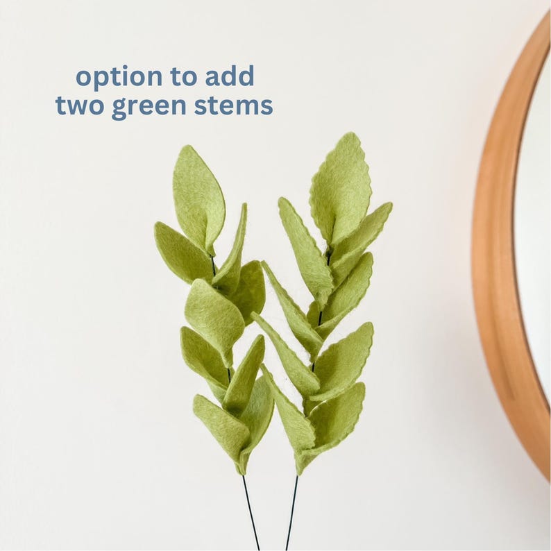 May include: Two green felt leaf stems with black wire stems. The leaves are a light green color and have a textured appearance. Text in the image reads: "option to add two green stems."