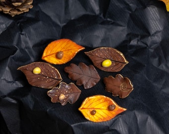 Pins with bramble and oak leaves and snail shells made of polymer clay