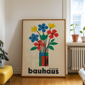 Pu&ograve; includere: Un poster incorniciato con un'illustrazione colorata di fiori in un vaso. Il poster &egrave; intitolato "botanisch bauhaus" e utilizza i colori rosso, blu, giallo e verde.