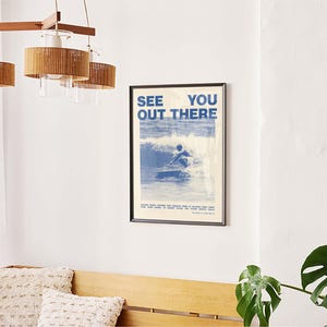 K&ouml;nnte beinhalten: Ein blaues und wei&szlig;es Poster mit dem Text "See You Out There" und einem Foto einer Person, die auf einer Welle surft.