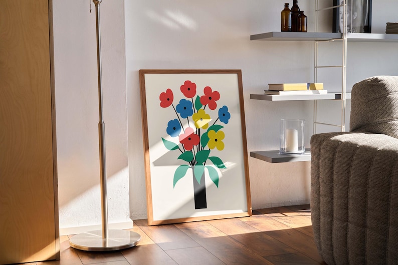 May include: A framed print of a colorful floral bouquet with red, blue, yellow, and green flowers in a black vase. The print is on a white background and has a wooden frame.
