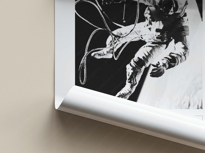 K&ouml;nnte beinhalten: Schwarzwei&szlig;foto eines Astronauten, der im Weltraum schwebt und an einem Raumschiff befestigt ist. Der Astronaut tr&auml;gt einen Raumanzug und h&auml;lt sich an einem Seil fest.