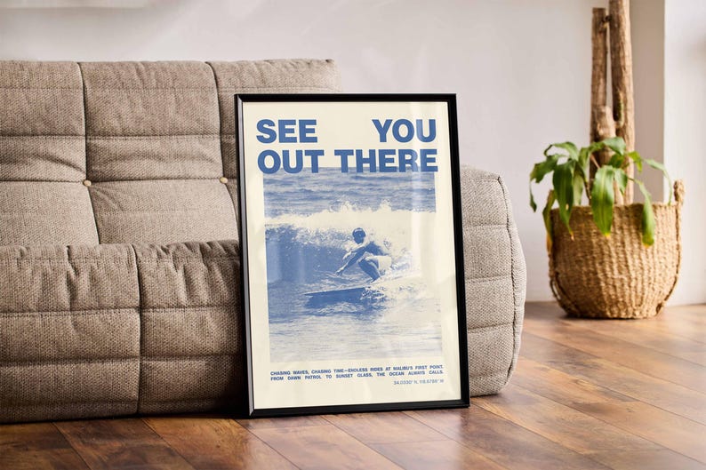 K&ouml;nnte beinhalten: Ein blaues und wei&szlig;es Poster mit dem Text "See You Out There" und einem Foto eines Surfers, der auf einer Welle reitet. Das Poster ist schwarz gerahmt und h&auml;ngt an einer Wand.